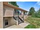 Backyard view showing walk-out basement access and modern railing detail on stairs leading to yard at 6307 S Gallup St, Littleton, CO 80120