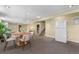 Spacious carpeted basement with a dining table, sitting area, and stairs to an upper level with laundry machines nearby at 6307 S Gallup St, Littleton, CO 80120