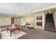 Finished basement featuring a seating area, stairs to upper level, and doorway to small kitchen space at 6307 S Gallup St, Littleton, CO 80120