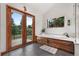 Spacious bathroom boasting a bathtub with patio access and views of the outdoor landscape at 6307 S Gallup St, Littleton, CO 80120