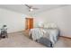 Bedroom with neutral carpet, white walls, ceiling fan, and a door at 6307 S Gallup St, Littleton, CO 80120