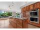 An open kitchen features a large island, stainless steel appliances and generous natural light from a wall of windows at 6307 S Gallup St, Littleton, CO 80120