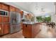 An eat-in kitchen with stainless steel appliances, an island, and large windows bringing in light and views of the outdoors at 6307 S Gallup St, Littleton, CO 80120