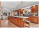 Gourmet kitchen featuring custom cabinets, hardwood floors, stainless steel appliances, and central island at 6307 S Gallup St, Littleton, CO 80120
