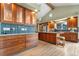 A spacious kitchen with custom cabinets, modern appliances, a blue tile backsplash, and an eat-in island with stool seating at 6307 S Gallup St, Littleton, CO 80120