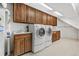 Functional laundry room with washer, dryer, utility sink, and ample cabinet space for storage at 6307 S Gallup St, Littleton, CO 80120