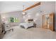 A spacious main bedroom suite with ample natural light, a sitting area, modern lighting, and a high vaulted ceiling at 6307 S Gallup St, Littleton, CO 80120