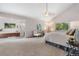 An airy main bedroom with vaulted ceiling, a sitting area, a large bed, and an attached en-suite bathroom with a soaking tub at 6307 S Gallup St, Littleton, CO 80120