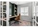 Stylish home office with a built-in desk, shelves, a comfortable chair, and natural light from the window at 2028 Trail Stone Ct, Castle Rock, CO 80108