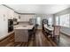Open-concept kitchen with white cabinetry, stainless steel appliances, and a center island with bar seating, seamlessly flows into the dining area at 2028 Trail Stone Ct, Castle Rock, CO 80108
