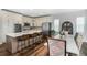 Well-lit kitchen with an island, seating, and dining area featuring stainless steel appliances and wood floors at 2028 Trail Stone Ct, Castle Rock, CO 80108