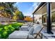 Well-maintained backyard featuring lounge chairs, green lawn, and landscaped greenery at 42 S Ash St, Denver, CO 80246