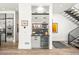 Modern bar area with a wine refrigerator, marble countertop, and custom cabinets next to the stairs at 42 S Ash St, Denver, CO 80246
