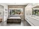 Luxurious bathroom with a marble soaking tub, tiled walls, and a large window for natural light at 42 S Ash St, Denver, CO 80246