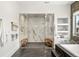 Contemporary bathroom with a marble walk-in shower, sleek fixtures, and built-in shelving at 42 S Ash St, Denver, CO 80246