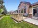 Beautiful backyard with a wooden deck, lush green lawn, and mature trees at 14310 Kalamath St, Westminster, CO 80023