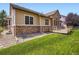 Expansive backyard with lush green grass, gravel area, and a wooden deck at 14310 Kalamath St, Westminster, CO 80023