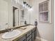 Bathroom featuring dual sinks, granite countertops, and updated lighting at 14310 Kalamath St, Westminster, CO 80023