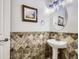 Powder room features pedestal sink, decorative mirror, and tasteful decor at 14310 Kalamath St, Westminster, CO 80023