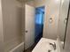 Bathroom view showcasing tub/shower, sink with chrome faucet, door ajar to a bedroom space at 17477 E Temple Dr, Aurora, CO 80015