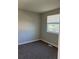 Cozy bedroom featuring neutral paint, plush carpeting, and a bright window at 17477 E Temple Dr, Aurora, CO 80015