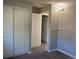 Bedroom with large closet, neutral walls, and a view into the next room at 17477 E Temple Dr, Aurora, CO 80015