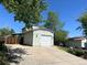 View of the home's garage with a large driveway and mature landscaping at 17477 E Temple Dr, Aurora, CO 80015