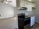 Functional kitchen with black oven open to living room with gray walls and carpet at 17477 E Temple Dr, Aurora, CO 80015