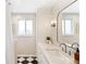 Elegant bathroom featuring a black and white checkerboard floor and modern finishes with gold fixtures and sleek mirror at 11223 W 29Th Ave, Lakewood, CO 80215