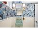 Charming bathroom with bold butterfly wallpaper, a mint green pedestal sink, and sleek gold fixtures at 11223 W 29Th Ave, Lakewood, CO 80215