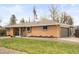 Well-maintained brick home with lush lawn, mature trees, and an attached garage at 11223 W 29Th Ave, Lakewood, CO 80215