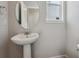 Bathroom featuring a round mirror and a pedestal sink at 5784 Farmstead Pl, Mead, CO 80504