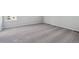 Bright bedroom with neutral carpeting, base trim and a window letting in natural light at 5784 Farmstead Pl, Mead, CO 80504