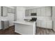 Clean kitchen with an island, gray cabinets, stainless appliances, and wood-look flooring at 5784 Farmstead Pl, Mead, CO 80504