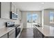 Kitchen with stainless steel appliances, center island, gray cabinets and sliding glass door at 5784 Farmstead Pl, Mead, CO 80504