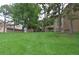 Apartment building exterior with large grassy area, mature trees, and serene atmosphere at 400 Zang St # 1-105, Lakewood, CO 80228