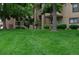 Building exterior with well-manicured lawn and mature trees, providing a serene setting at 400 Zang St # 1-105, Lakewood, CO 80228