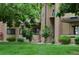 Apartment building facade showing unit numbers and lush, green lawn with mature trees at 400 Zang St # 1-105, Lakewood, CO 80228