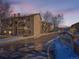 Exterior shot of a multi-story condo building with balconies and wet asphalt on a sunny winter day at 400 Zang St # 1-105, Lakewood, CO 80228