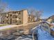 View of the apartment complex featuring multiple balconies and well-kept grounds during the winter season at 400 Zang St # 1-105, Lakewood, CO 80228