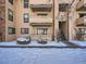 Exterior of the building showcasing private balconies and well-maintained landscaping in winter at 400 Zang St # 1-105, Lakewood, CO 80228