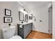 Bright bathroom featuring double sinks, modern vanity, decorative mirrors, and updated lighting at 201 Wright St # 105, Lakewood, CO 80228