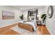 Bedroom with hardwood floors, natural light, decor, and a large window with tree-filled landscape views at 201 Wright St # 105, Lakewood, CO 80228