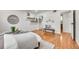 Bedroom with hardwood flooring, coordinated decor, and a view into an en-suite bathroom and mirrored closet at 201 Wright St # 105, Lakewood, CO 80228