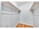 Simple, light blue walk-in closet with hardwood floors and white shelving racks at 201 Wright St # 105, Lakewood, CO 80228