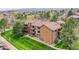 Exterior showcasing the brown multi-story condo building and well-manicured green lawn at 201 Wright St # 105, Lakewood, CO 80228