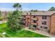 Charming multi-story condo building with landscaped lawn and tree coverage at 201 Wright St # 105, Lakewood, CO 80228