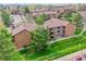 Aerial view of the multi-story condo building and surrounding green lawn at 201 Wright St # 105, Lakewood, CO 80228