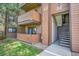 Apartment exterior with wood paneling, balconies, and staircase leading to unit entrances at 201 Wright St # 105, Lakewood, CO 80228