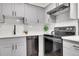 The kitchen features a stainless steel dishwasher and range with white subway tile backsplash and light gray cabinetry at 201 Wright St # 105, Lakewood, CO 80228